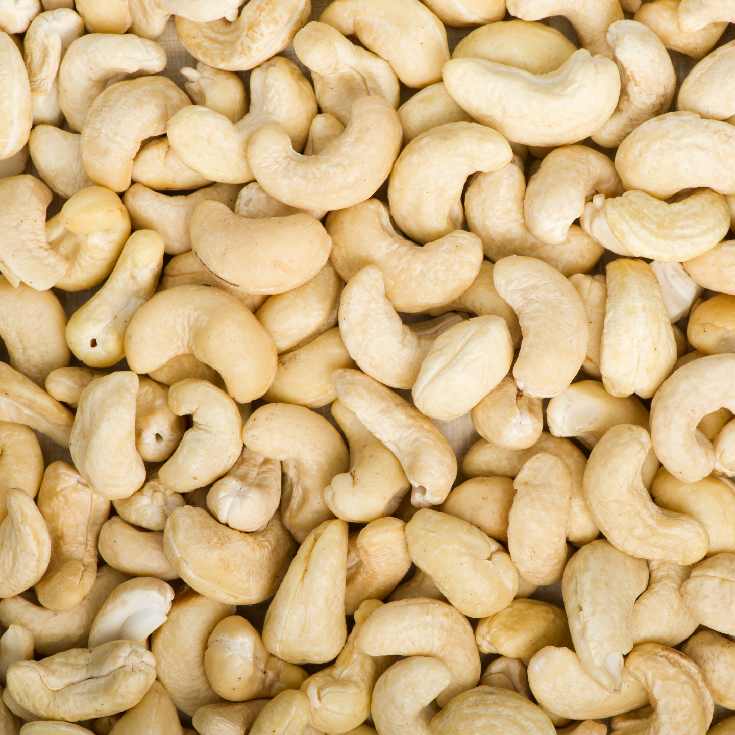 close-up of raw organic cashew nuts showing creamy colour and curved shape